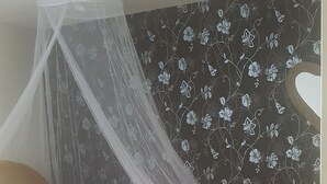 A bedroom with a bed under a canopy, a floral wallpaper, and a wooden floor. - Character house (PUIMISSON)