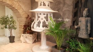 A room with a stone wall, a white decorative lantern, and a statue. - Character house (PUIMISSON)
