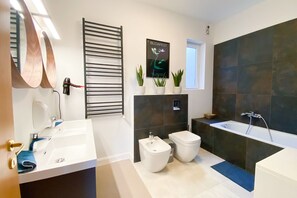 Kombination af bruser/badekar, hårtørrer, bidet, håndklæder