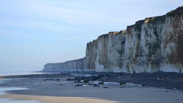 Un paysage côtier avec des falaises et une plage de sable.