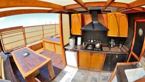 A compact kitchen with wooden cabinets, a black range hood, and a small countertop. - Unique off Grid Desert Retreat, California, USA (Hesperia)