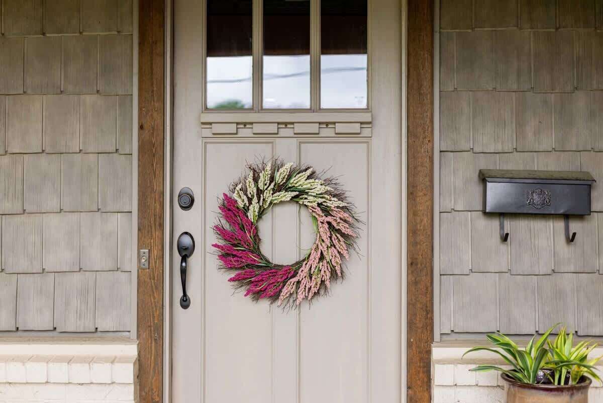 A door with a wreath, a mailbox, and a potted plant.