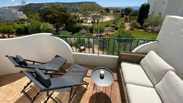 A balcony with a sofa, two lounge chairs, and a small table. - Serenity & design T3, 2 terraces seaview 600m beach (Praia da Luz)