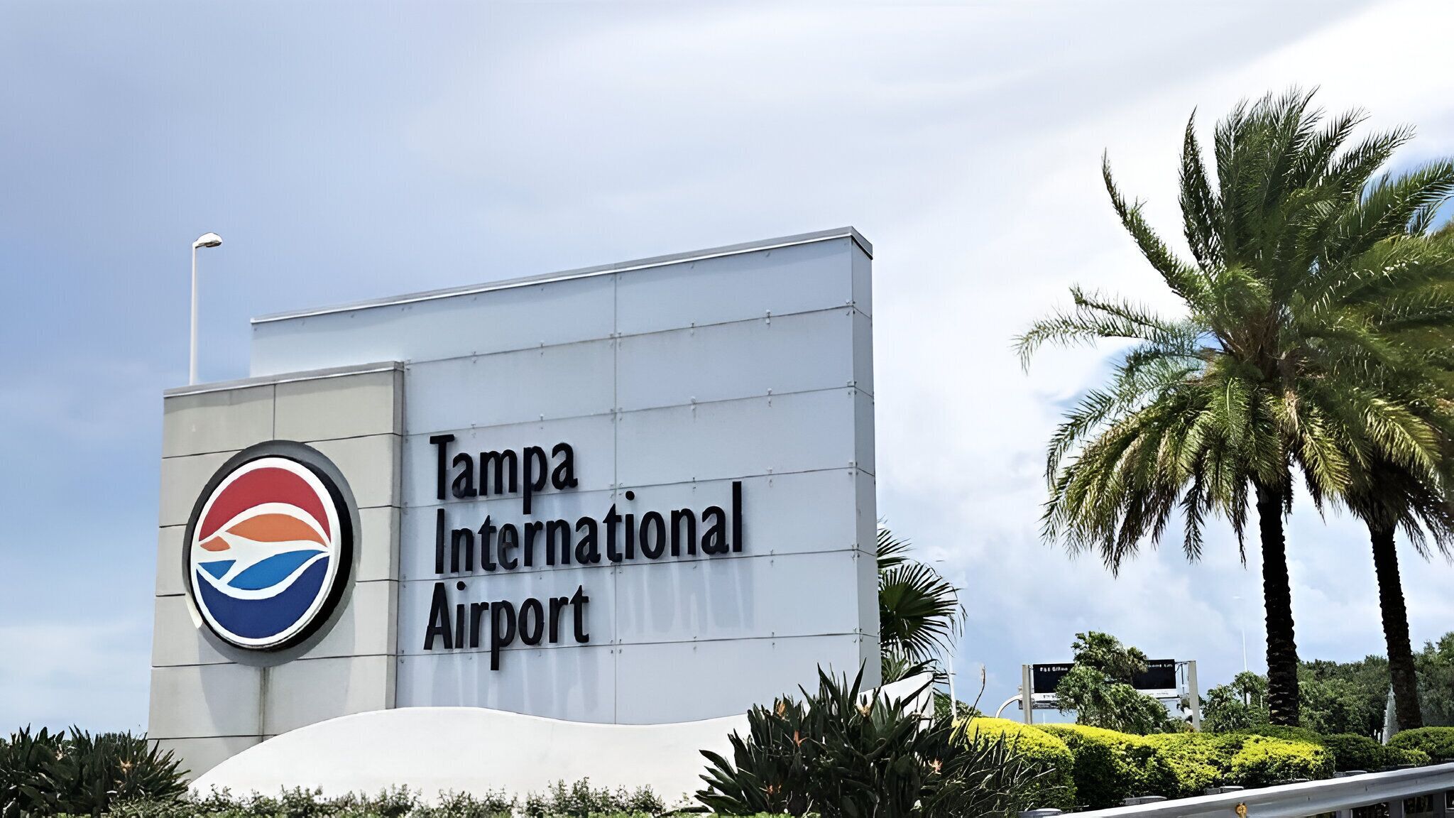A sign for Tampa International Airport with a logo and the name of the airport.