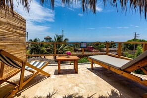 Quarto quádruplo standard, vista parcial para o oceano | Roupa de cama