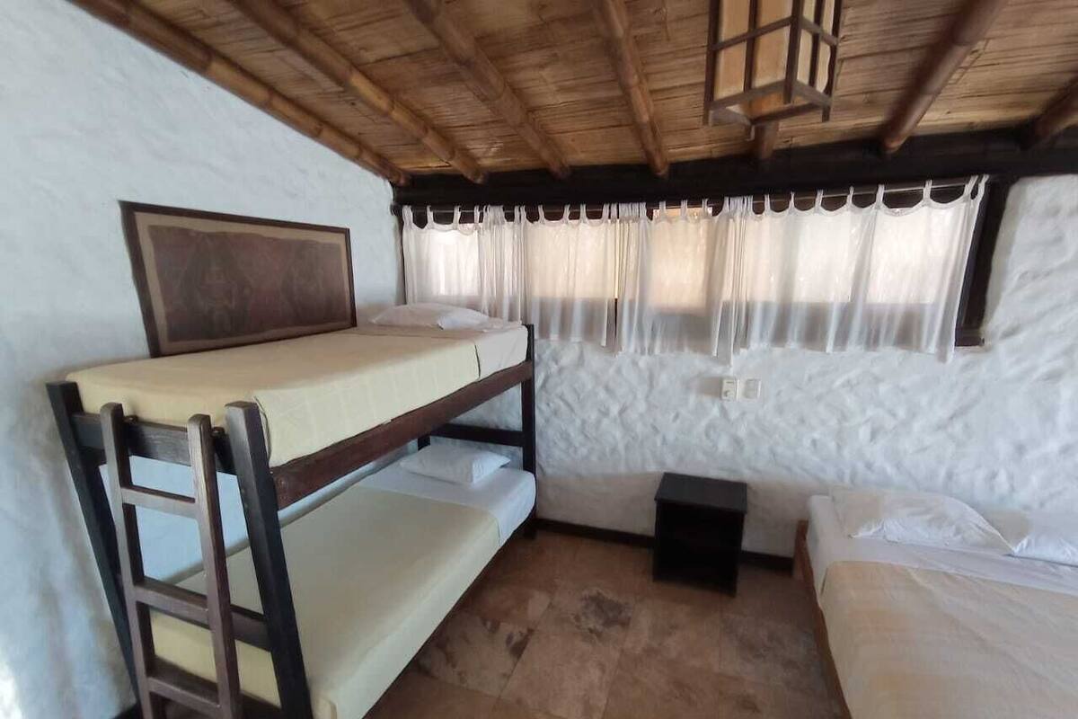 Une chambre avec un lit superposé, un bureau et une chaise.