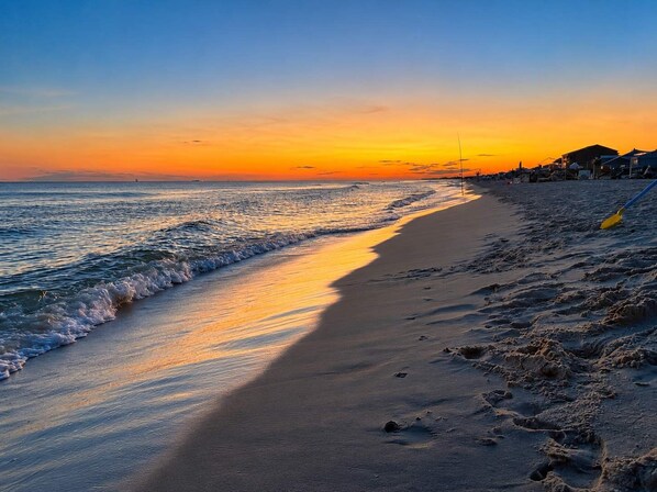Een strand met heldere lucht en een zonsondergang.