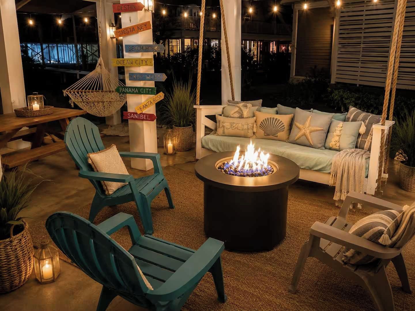 Un espace extérieur aménagé avec un foyer, des chaises turquoise et un fauteuil suspendu.