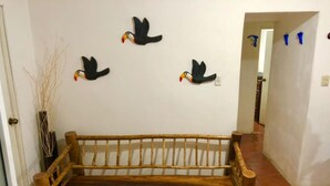 Un banco de madera en un pasillo con suelo de baldosas y una pared blanca.