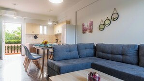 Una sala de estar moderna con un sofá gris, una mesa de centro de madera y un comedor con una mesa y sillas.