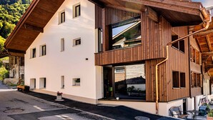 Ein zweistöckiges Gebäude mit modernem Design, das große Fenster und Holzverkleidung aufweist.