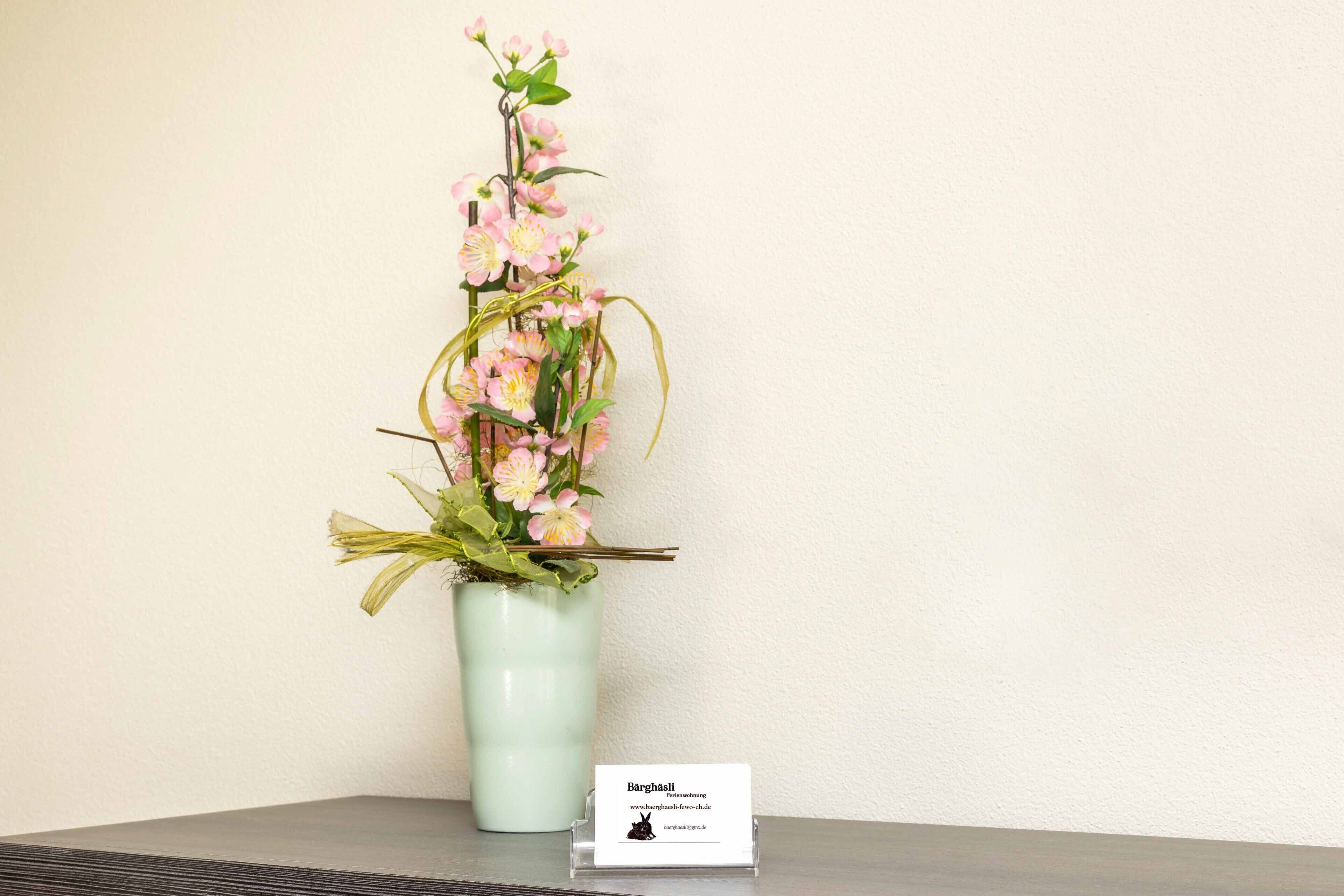 Un vase contenant une composition florale, posé sur une table.