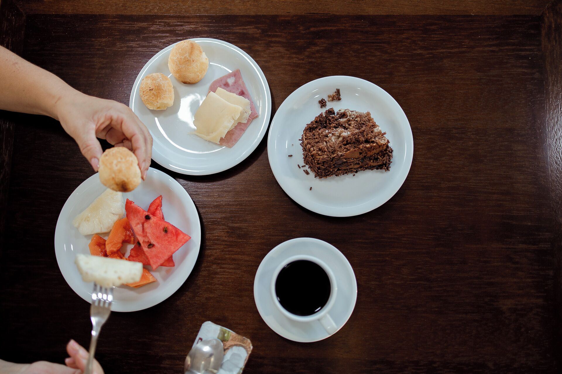 Uma mesa com pratos de comida, uma xícara de café e uma colher.