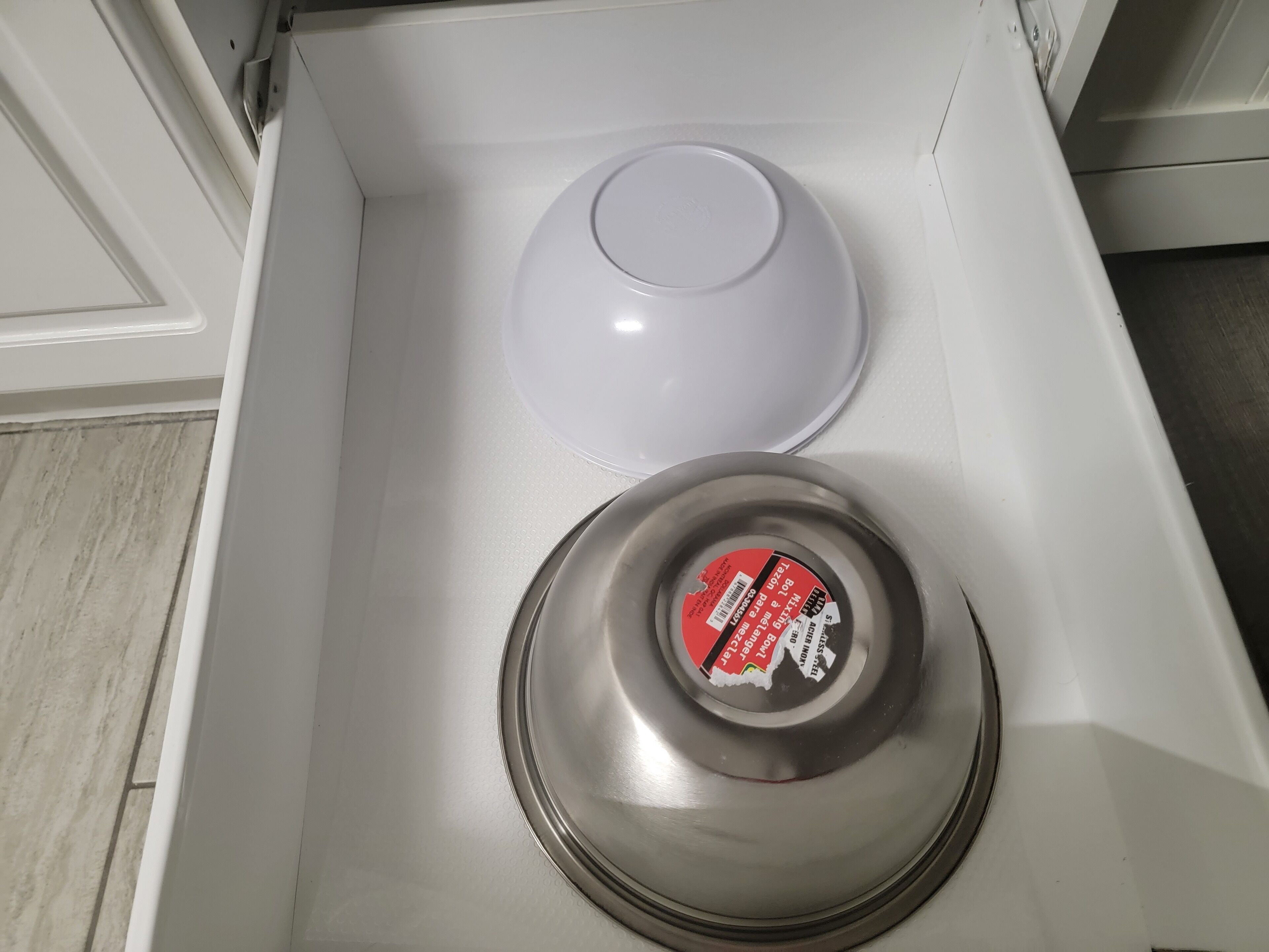 Un cajón blanco con tapa blanca y tapa metálica con etiqueta roja.
