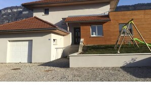 A two-story house with a garage and a wooden extension.