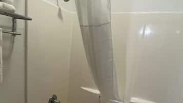 A bathroom with a shower curtain, a towel rack, and a toilet.
