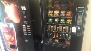 Two vending machines with snack options and a drink dispenser. - Motel 6 Portland, IN (Portland)