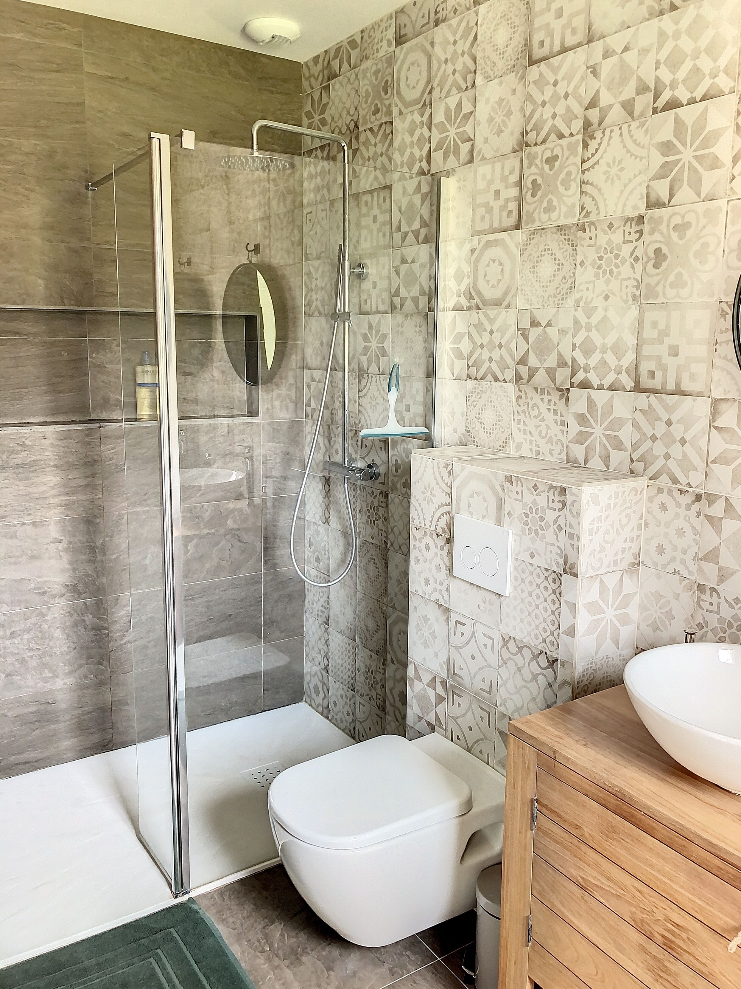 A modern bathroom with a glass-enclosed shower, a toilet, and a vanity with a sink.