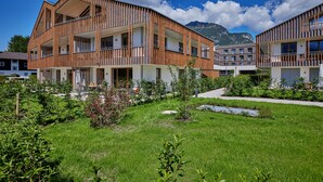 A modern building with multiple balconies and a well-maintained garden area. - Beary - modern ground floor flat in best location (Garmisch-Partenkirchen)