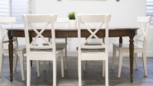 A dining area with a wooden table and white chairs, a framed quote on the wall, and a potted plant on the table. - Modern 3-bedroom Guest Suite by Silicon Slopes (Eagle Mountain)