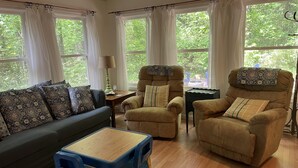A living room with a sofa, two armchairs, a small table, and a lamp. - Beach House in waterfront gated community w/ salt water pool (Lewes)