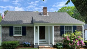 Une maison de plain-pied avec un porche à l’avant, une cheminée et une boîte aux lettres.