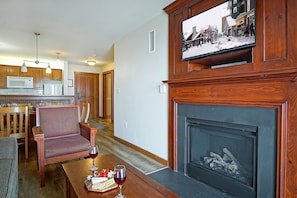 Cozy living room with a fireplace, TV, and dining area, perfect for relaxation and entertainment.
