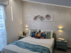 Ein modernes Schlafzimmer mit einem Bett, zwei Nachttischen, einer Wandleuchte und einem Fenster mit Vorhängen.