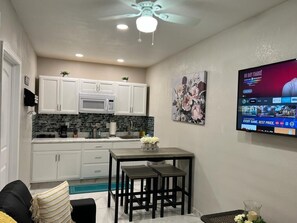 Cozy living space with a kitchenette, flat-screen TV, and dining area.