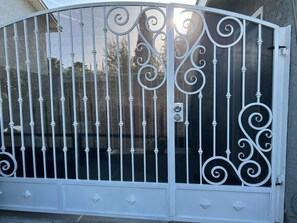 The entrance features a beautifully crafted metal gate with intricate scrollwork designs.