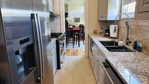 A modern kitchen with stainless steel appliances, granite countertops, and a central island.