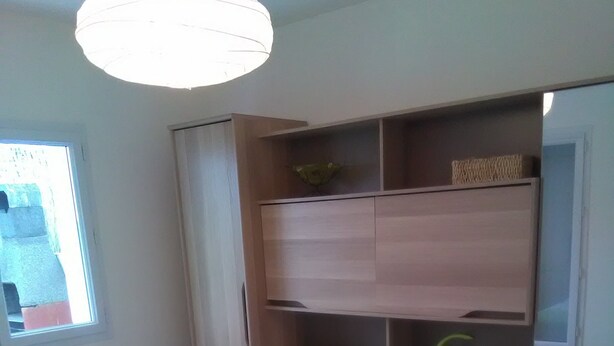 Un dormitorio con dos camas, un armario empotrado y una ventana.