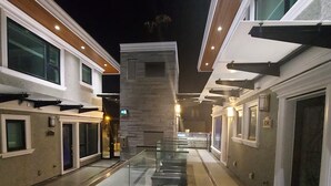 Ein Korridor mit Glasgeländern, einer zentralen Treppe und einem Gebäude mit steinernen Fassade.
