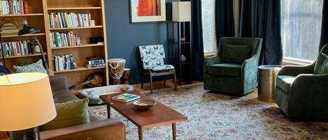 A cozy living room with a bookshelf, a coffee table, and a sofa.