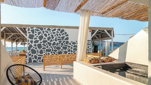 A rooftop terrace with a stone wall, a wooden bench, a lounge chair, and a hot tub. - ISLAND CONCEPT CHANIA (Chania)
