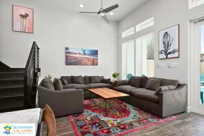 A modern living room with a sectional sofa, a coffee table, and a colorful rug.