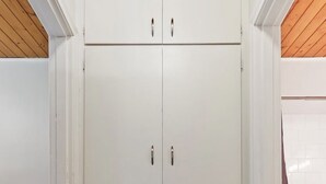 Um guarda-roupa branco com duas portas e cinco gavetas.