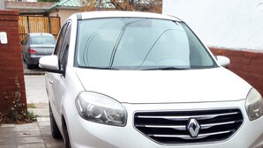 A white car parked on a tiled driveway.