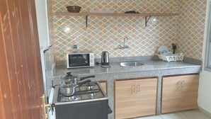 Eine kleine Küche mit Mikrowelle, Toaster, Spüle und Herd.