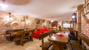 A rustic dining area with brick walls, wooden benches, and a red sofa. - Stunning home in Starigrad with sauna (Starigrad)