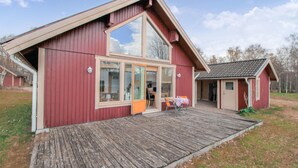 A red wooden building with a large glass door and a small attached structure. - 1 bedroom lovely home in Bolmsö (Bolmsö)