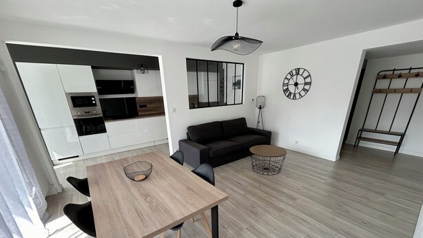 A modern living space with a dining area, a sofa, and a kitchen. - Beautiful flat close to the city centre! (Quimper)