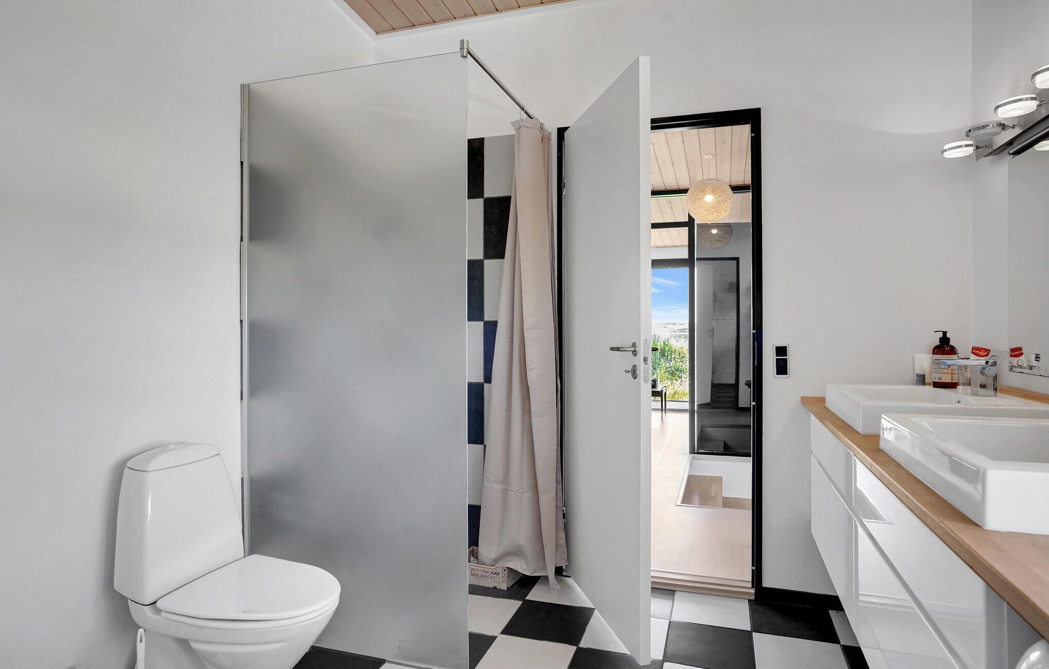 A modern bathroom with a toilet, a shower area, and a sink.
