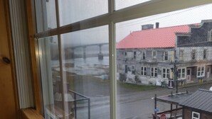 A window with a view of a parking lot and buildings. - Eastern Beacon Inn Room 3 (Lubec)