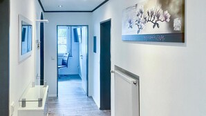 A hallway with a wooden floor, a radiator, and a framed artwork on the wall. - Nice apartment in Marienmünster (Marienmünster)