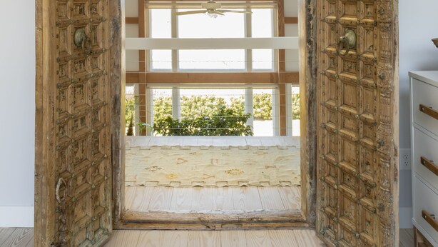 A room with a large wooden door leading to a garage. - Private Hilltop Chilmark Estate with private tennis court, gym and hot tub (Chilmark)