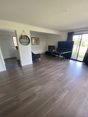 Relax in this stylish living area with a sofa, flat-screen TV, and potted plants.