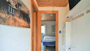 A narrow hallway leading to a bedroom with a bed, a small white refrigerator, and a wall-mounted shelf. - Pet friendly home in Skeppshult (Skeppshult)