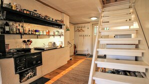 A kitchen with wooden shelves, a stove, and a white staircase. - Pet friendly home in Skeppshult (Skeppshult)