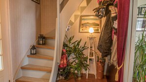 A staircase with wooden steps and a red curtain. There are plants and a lantern on the stairs. - Amazing home in Ytterøy with WiFi (Ytterøy)